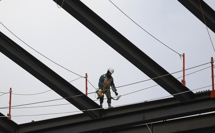 © Reuters. A worker labours at a construction site in Seoul