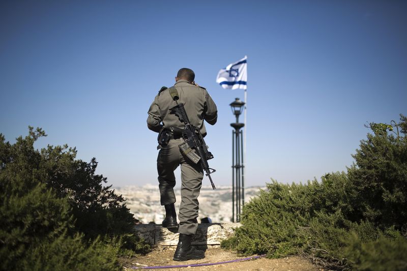 © Reuters. Policial de fronteira de Israel com a bandeira israelense ao fundo, em Jerusalém 