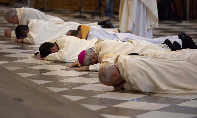 © Reuters. Archbishop of Granada Martinez and priests prostrate in front of the altar to seek pardon for sexual abuse in the Church at the cathedral in Granada