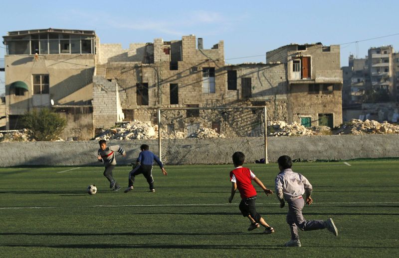 © Reuters. File photo shows boys playing with a soccer ball in the al-Klaseh neighbourhood of Aleppo