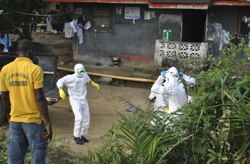 © Reuters. Medical staff wearing protective suits gather at a health facility near the Liberia-Sierra Leone border in western Liberia