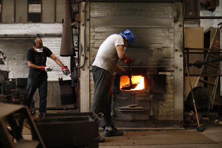 © Reuters. Employees work using a coal oven at the Rivierre plant, the last remaining nails factory in operation in France, in Creil