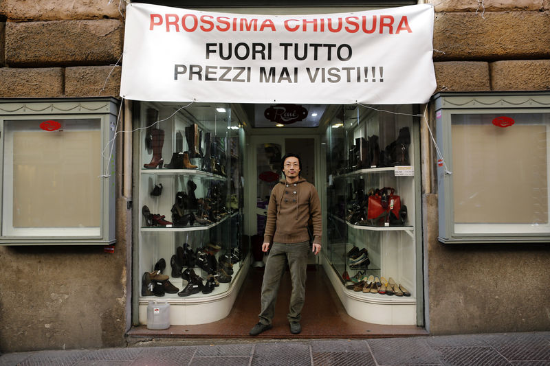 © Reuters. Renato Gu poses for a portrait outside his women's shoe and accessory shop in Rome