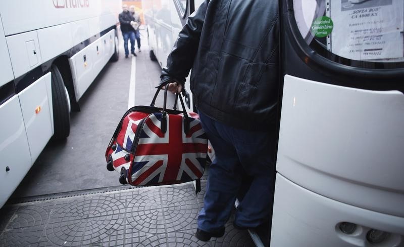 © Reuters. A man carrying a bag adorned with a British Union Jack flag steps into bus departing from Sofia's central bus station to London