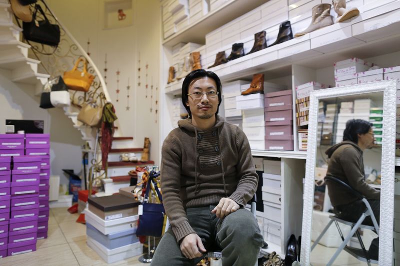 © Reuters. Renato Gu poses for a portrait inside his women's shoe and accessory shop in Rome