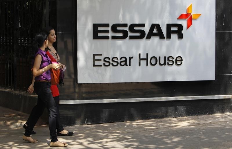 © Reuters. Employees walk past an Essar Group logo outside their headquarters in Mumbai