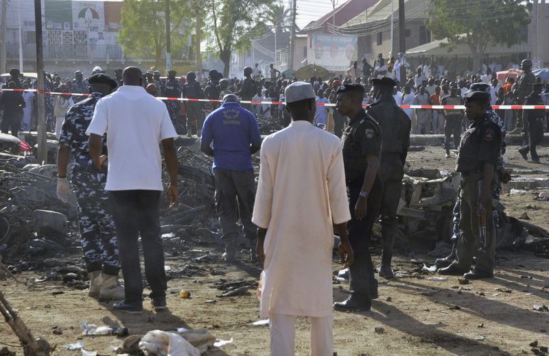 © Reuters. Esquadrão antibombas e agentes inspecionam local de explosão em Kano