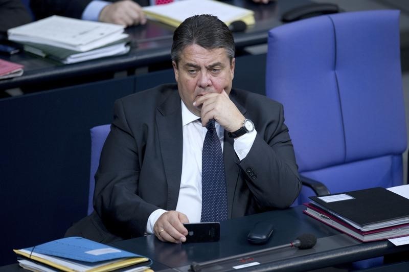 © Reuters. Germany's Economy Minister Gabriel holds a phone during a debate at the lower house of parliament Bundestag in Berlin