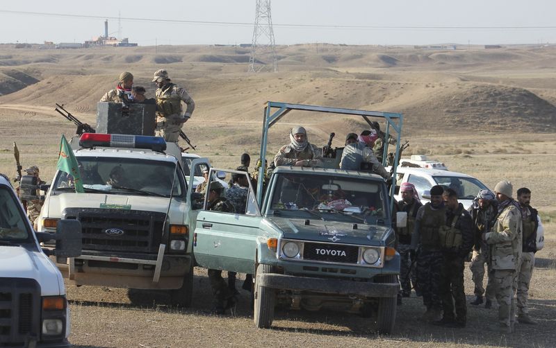 © Reuters. Members of the Iraqi security forces and Shi'ite fighters take part during an intensive security deployment in the town of Qara Tappa in Iraq's Diyala provinc