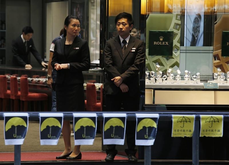 © Reuters. Sales persons wait for customers at a jewelry store at a road occupied by pro-democracy protesters at Mongkok shopping district in Hong Kong