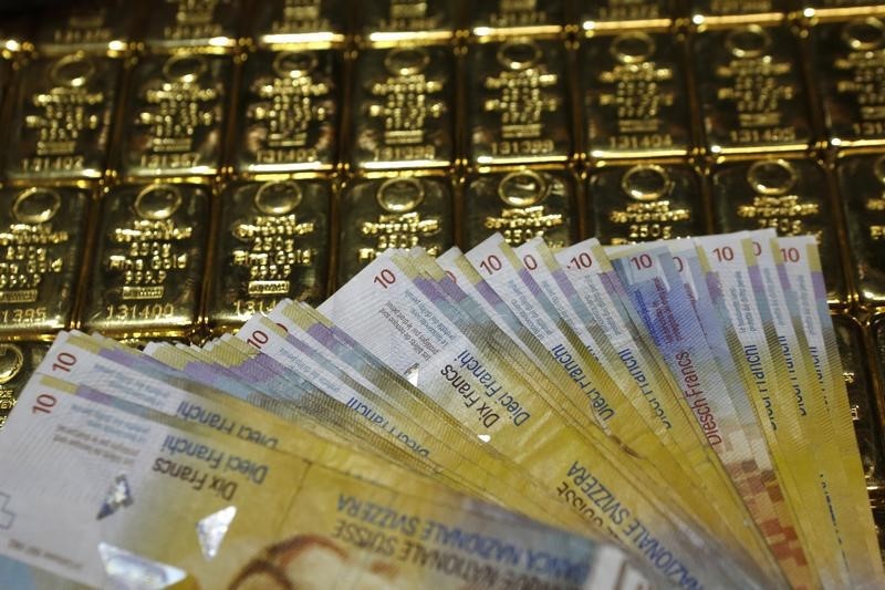 © Reuters. Gold bars and Swiss Franc banknotes are seen in this illustration picture in Vienna