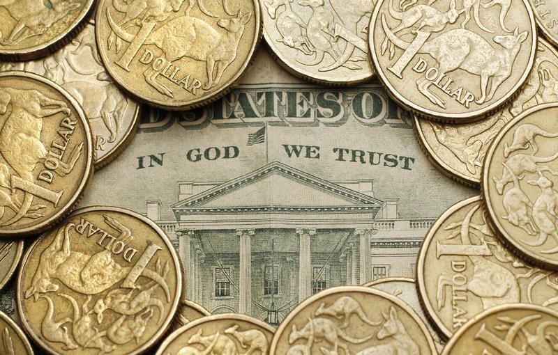 © Reuters. Photo illustration shows Australian one dollar coins surrounding a U.S. twenty dollar note in Sydney