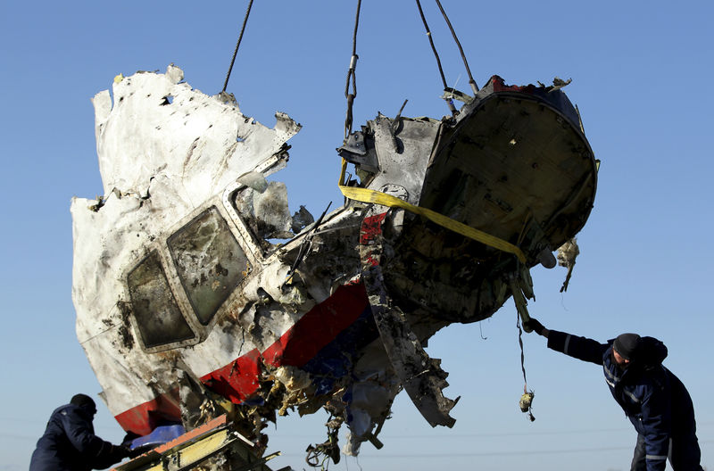 © Reuters. Local workers transport a piece of the Malaysia Airlines flight MH17 wreckage at the site of the plane crash near the village of Hrabove (Grabovo) in Donetsk region