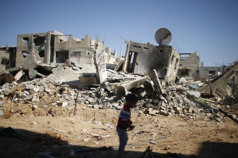 © Reuters. A Palestinian boy plays near the ruins of his family's house  in the east of Gaza City