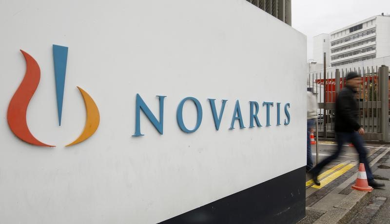 © Reuters. A man walks past the logo of Swiss drugmaker Novartis AG in front of a plant in Basel