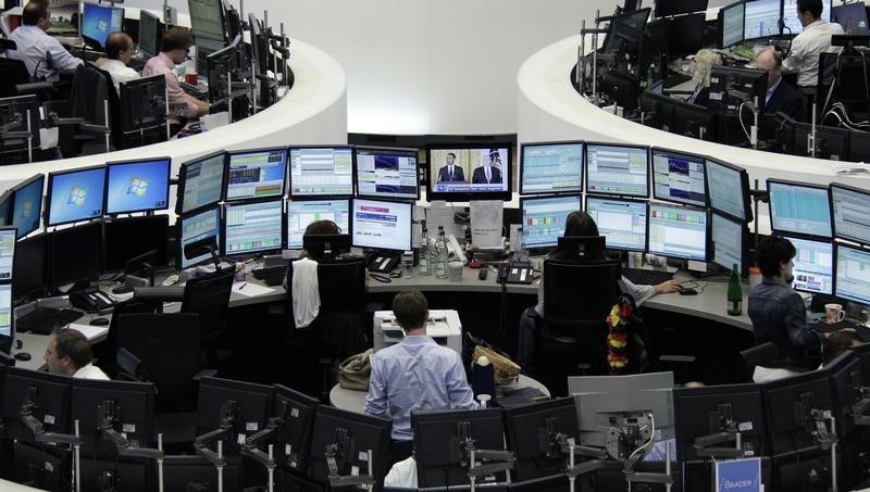 © Reuters. Traders are pictured at their desks in front of the DAX board at the Frankfurt stock exchange