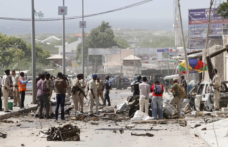 © Reuters. Somali security and investigators gather at the scene of an explosion in front of the airport in Somalia's capital Mogadishu