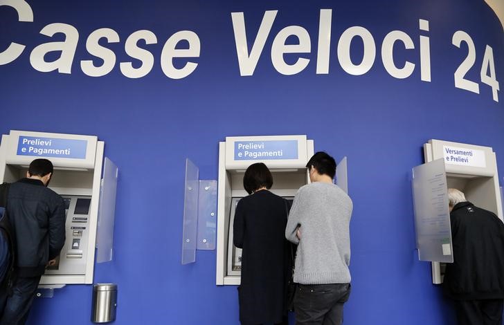 © Reuters. People use Intesa Sanpaolo automated teller machines (ATMs) in Milan