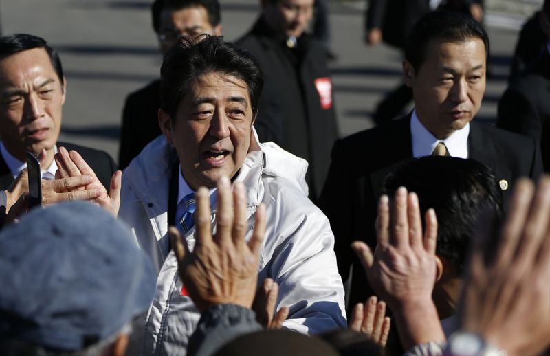 © Reuters. Japan's PM Abe gives high-fives to supporters during his official campaign kick-off in Soma, Fukushima prefecture