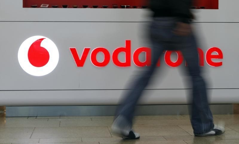 © Reuters. A customer walks past the Vodafone logo in a shopping mall in Prague