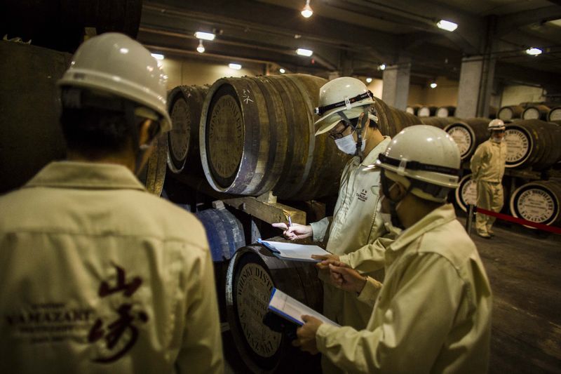 © Reuters. Workers check on casks in Suntory Holdings' Yamazaki Distillery in Shimamoto town