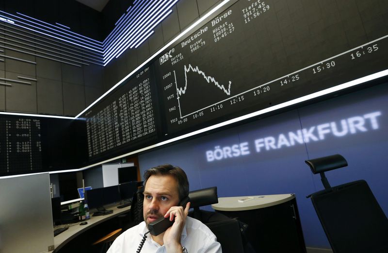 © Reuters. A trader is pictured at his desk in front of the German share price index DAX board at the Frankfurt stock exchange