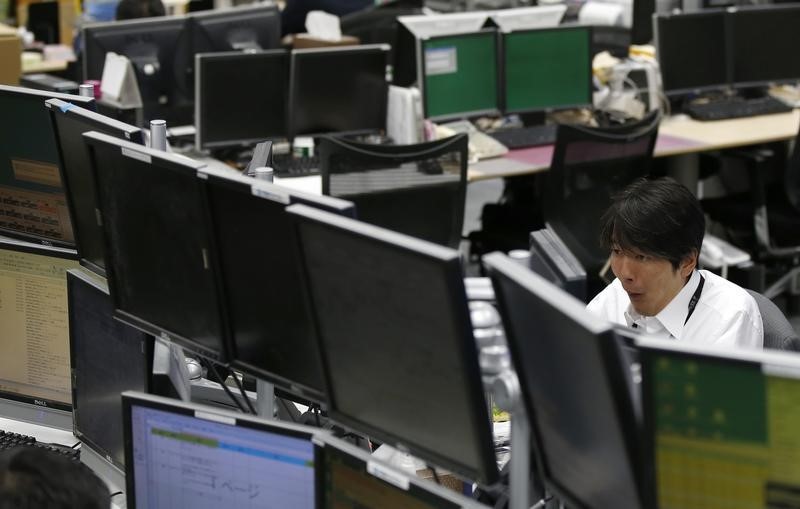 © Reuters. An employee of a foreign exchange trading company looks at monitors in Tokyo