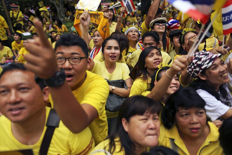 © Reuters. Well-wishers look toward the building where Thailand's King Bhumibol Adulyadej is residing at Siriraj hospital in Bangkok as people gather to pray for his health and celebrate his birthday