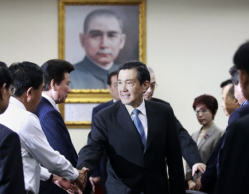 © Reuters. Taiwan President Ma Ying-jeou shakes hands with Kuomintang (KMT) party officials after announcing his resignation from the party's chairman position during their central standing committee in Taipei