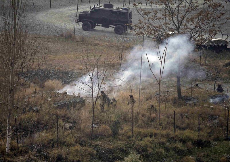 © Reuters. Indian army soldiers search for suspected militants as smoke rises from a bunker after a gunbattle at Mohra, in Uri