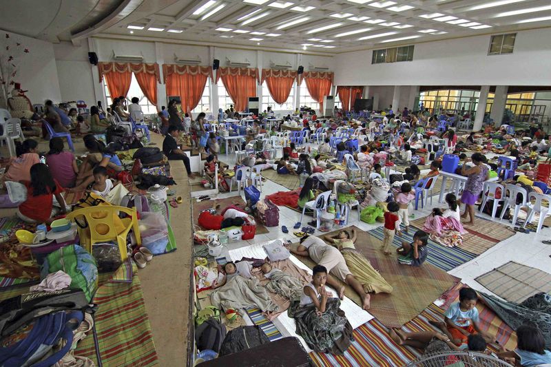 © Reuters. People take shelter inside a evacuation center after evacuating their homes due to super-typhoon Hagupit in Surigao city, southern Philippines