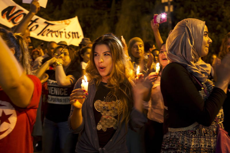 © Reuters. People attend a protest to condemn an attack by a gunman at the beach of the Imperial Marhabada hotel in Sousse