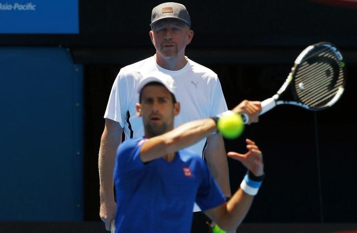 © Reuters. Serbia's Novak Djokovic hits a shot as he is watched by his coach Boris Becker during a practice session on Rod Laver Arena at Melbourne Park