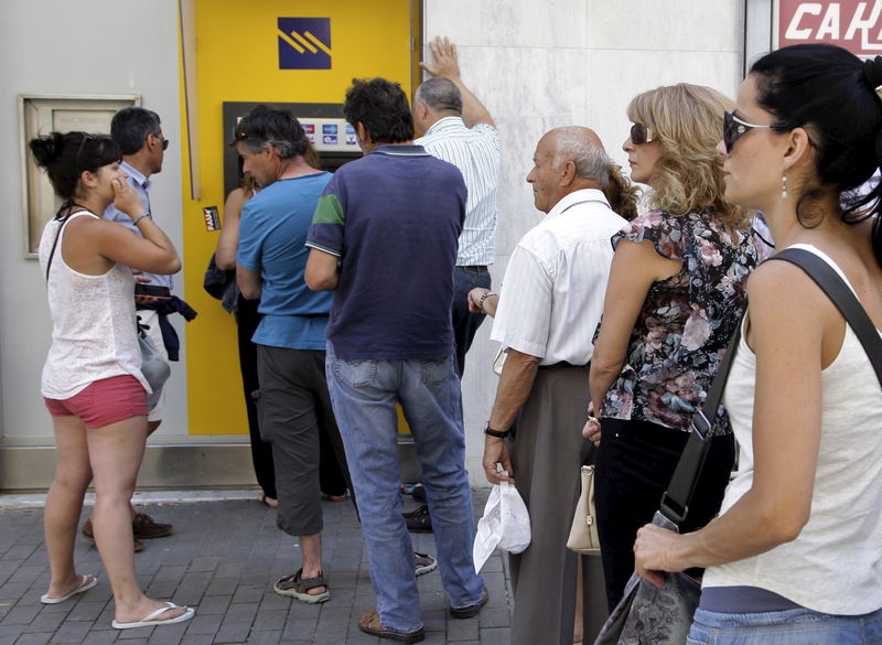 © Reuters. Griegos hacen fila frente a los cajeros automáticos en una filial del Banco Piraeus en la isla de Creta