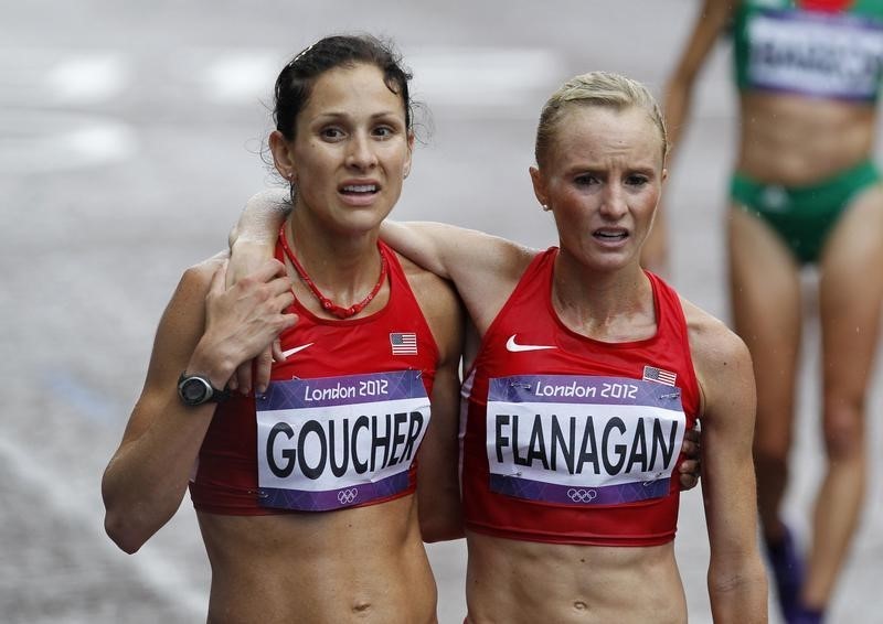 © Reuters. Kara Goucher of the U.S. helps her compatriot Shalane Flanagan after finishing the women's marathon final at the London 2012 Olympic Games at The Mall