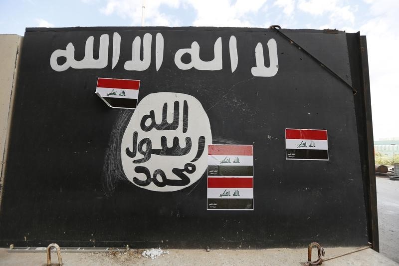 © Reuters. A wall painted with the black flag commonly used by Islamic State militants, near former Iraqi president Saddam Hussein's palace in Tikrit 