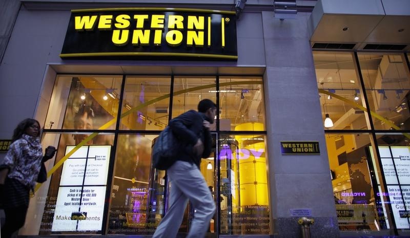 © Reuters. People walk past a Western Union branch at Times Square in New York