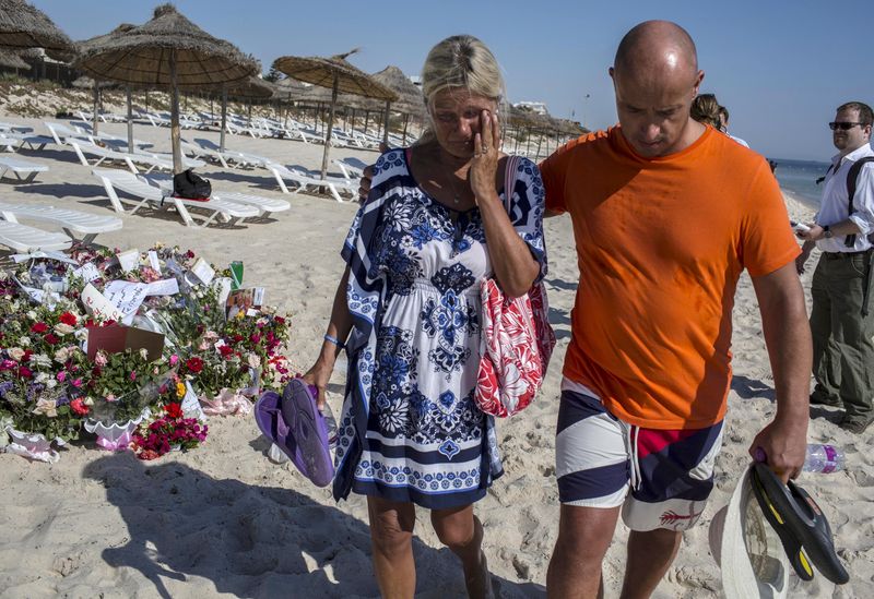 © Reuters. A tourist reacts after paying tribute at a makeshift memorial at the beachside of the Imperial Marhaba resort, which was attacked by a gunman in Sousse