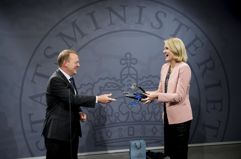 © Reuters. Former Danish Prime Minister Thorning-Schmidt smiles as she receives gifts from newly elected Danish Prime Minister Rasmussen in Copenhagen