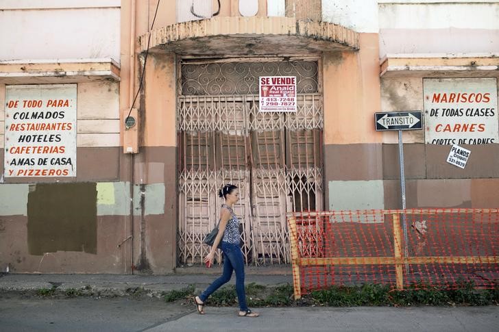 © Reuters. A woman walks past a closed restaurant in Ponce