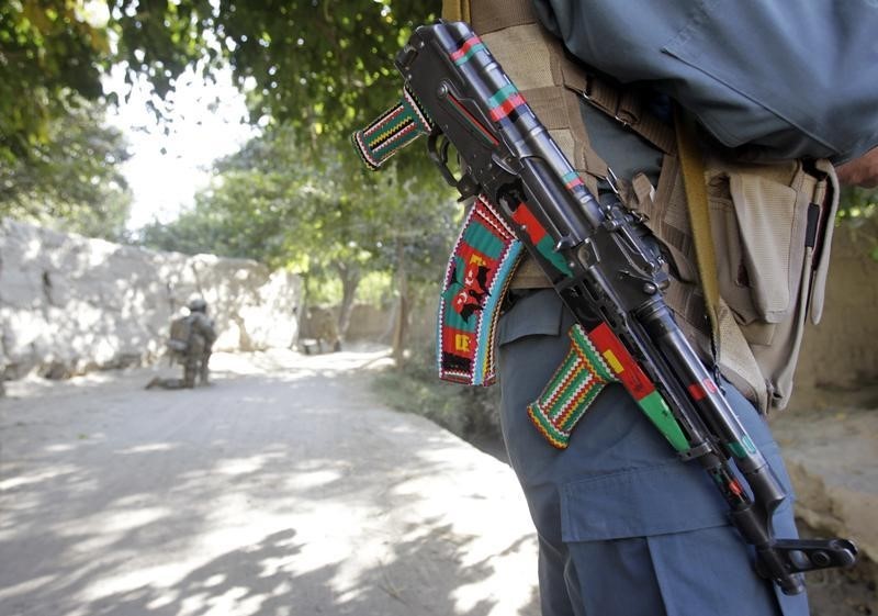 © Reuters. An Afghan policeman stands guard as he carries his weapon decorated with colourful stickers during a joint U.S.-Afghan military clearing operations in Nagahan district in Kandahar province