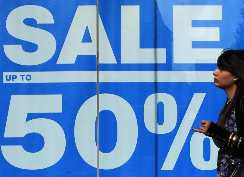 © Reuters. A shopper passes an advertisement on a shop in Oxford Street in London