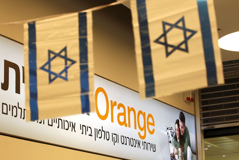 © Reuters. Israeli flags hang next to the logo of Orange mobile company in a store at a Jerusalem mall