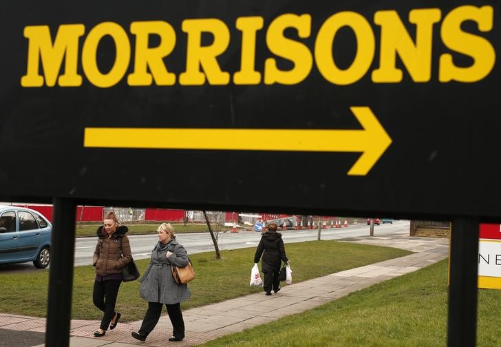 © Reuters. People walk beneath a sign outside a Morrisons supermarket in Liverpool, northern England