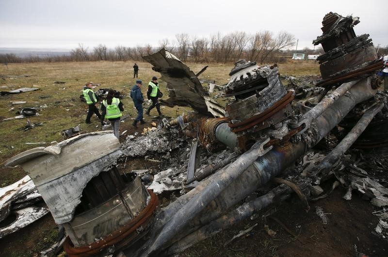 © Reuters. Dutch investigators and an Emergencies Ministry member work at the site where the downed Malaysia Airlines flight MH17 crashed, near the village of Hrabove in Donetsk region