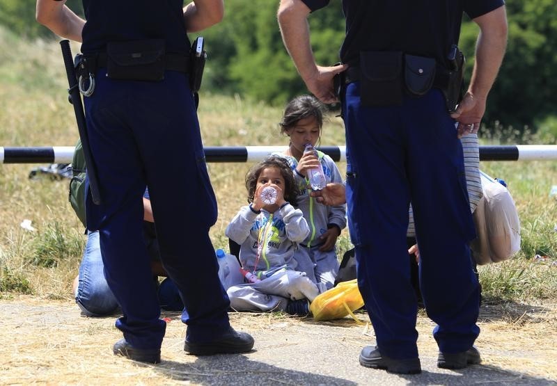 © Reuters. Ungheria, agenti di polizia controllano migranti siriani che hanno attraversato confine da Serbia