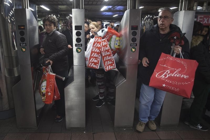 © Reuters. Shoppers enter the 34th Street subway station with packages on Black Friday in New York