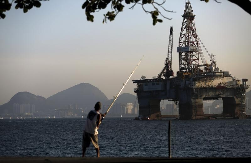 © Reuters. A man fishes near an oil platform in Niteroi