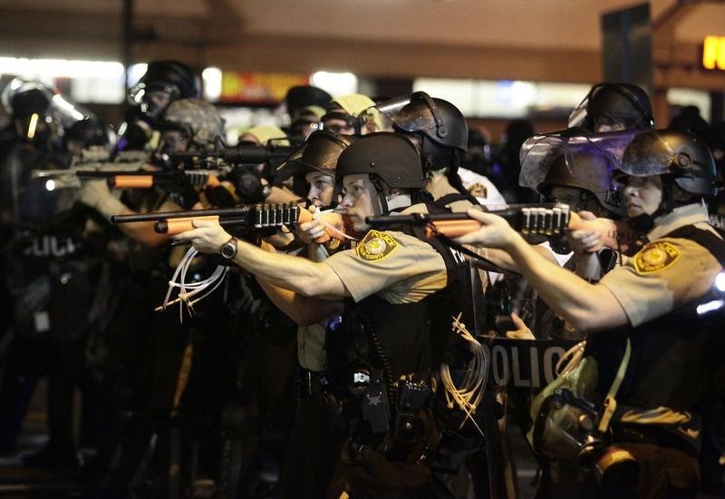 © Reuters. Police officers point their weapons at demonstrators protesting against the shooting death of Michael Brown in Ferguson, Missouri