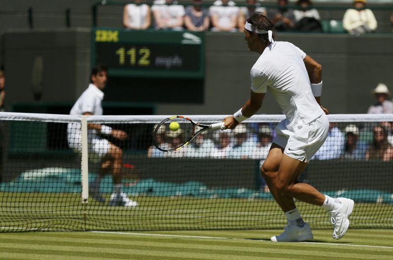 © Reuters. Rafael Nadal of Spain hits a volley during his match against Thomaz Bellucci of Brazil at the Wimbledon Tennis Championships in London